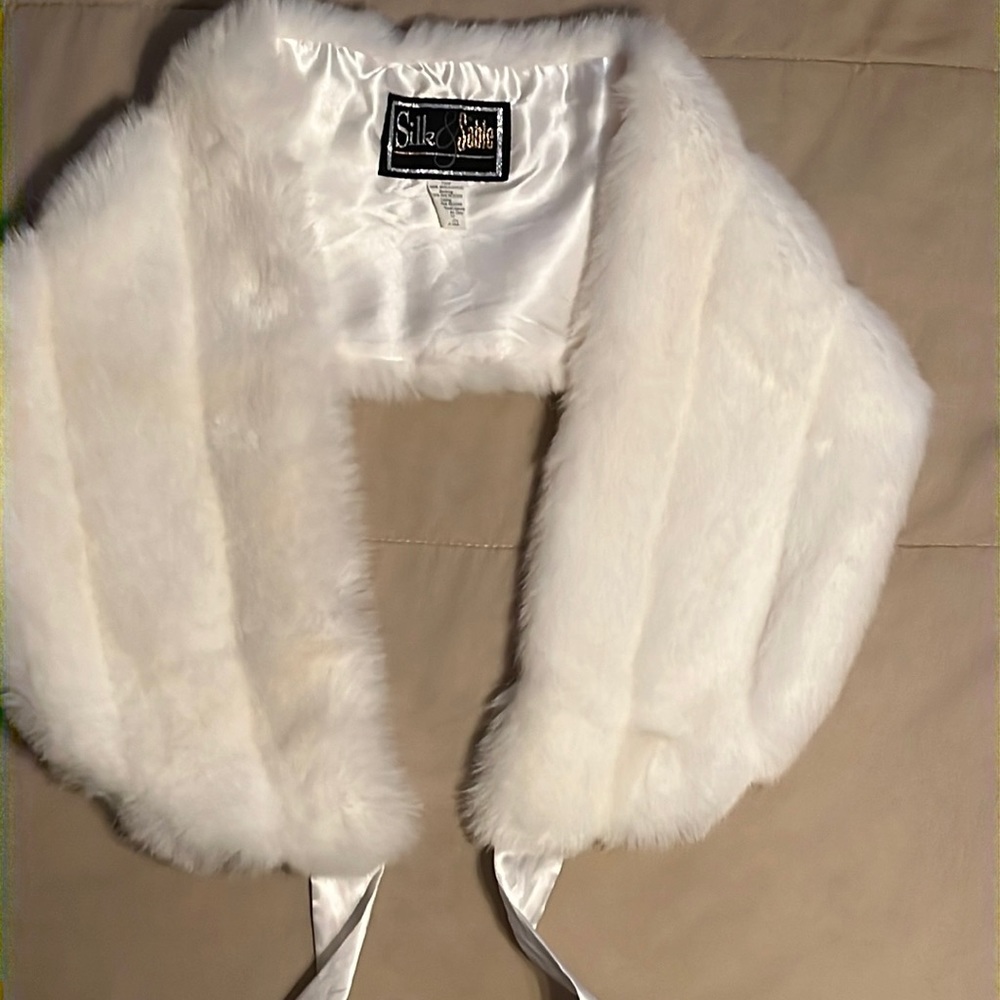 Never worn. White faux fur shawl with silk ties